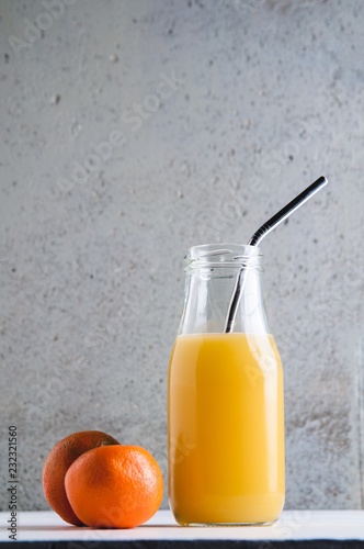 orange juice in a bottle with a reuseable metal straw