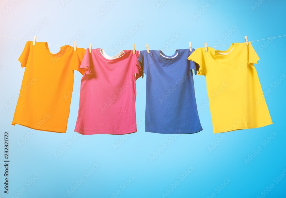 Colorful T-shirts hanging on a rope on a white background Colorful T-shirts hanging on a rope on a white background