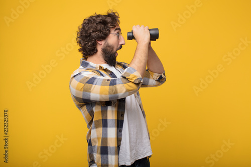young crazy mad man  fool pose with a binoculars photo