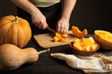 The cook slices the pumpkin for baking.