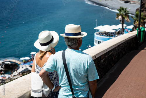 Adult couple in hats on a walk along the promenade.