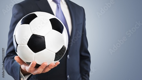 Fototapeta Naklejka Na Ścianę i Meble -  Close-up young male businessman holding Soccer ball
