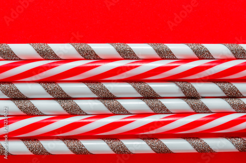 Festive Christmas background of plastic tubes for a cocktail on a red background