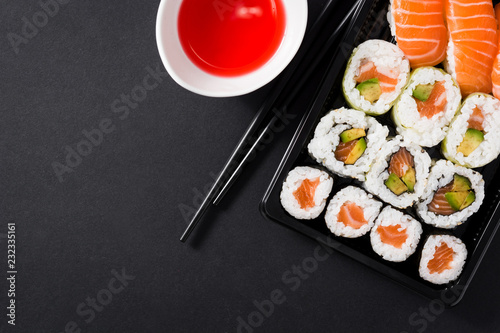 Japanese food: maki and nigiri sushi set on black background. Flat lay top-down composition. Copyspace