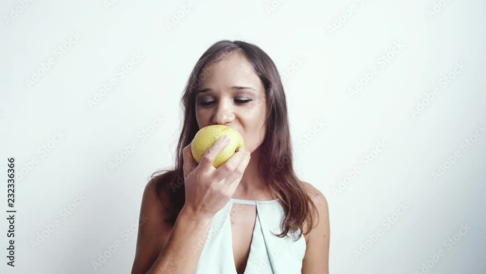 Beautiful young joyful woman eating green apple fruit. Isolated on White Background. 3840x2160 Beautiful young joyful woman eating green apple fruit. Isolated on White Background. 3840x2160