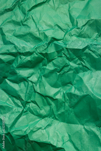 A crumpled green sheet of paper. Vertical background.
