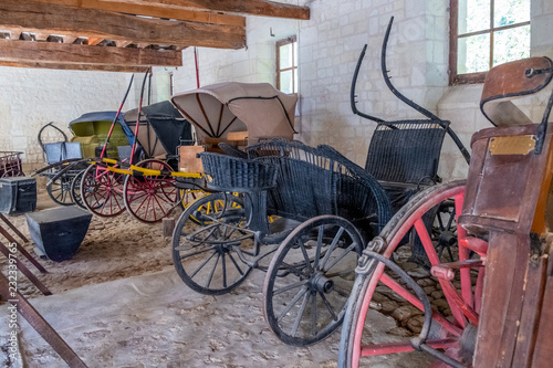 Vintage carriages on display in the stable of medieval castle in France.