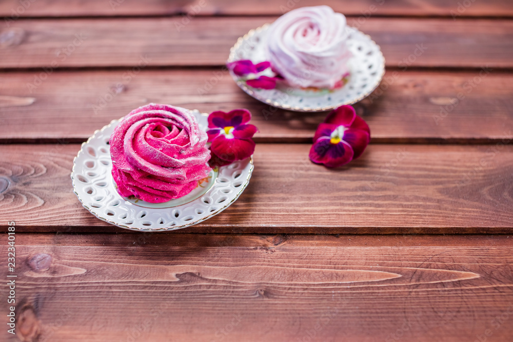 Sweet dessert white,pink zephyr marshmallows on clay plate and rustic wooden background.Marshmallow, Meringue, Zephyr. Selective focus.Copy space Sweet dessert white,pink zephyr marshmallows on clay plate and rustic wooden background.Marshmallow, Meringue, Zephyr. Selective focus.Copy space