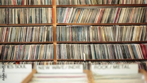 Dolly shot of racks of LP vinyl records on display in music store
