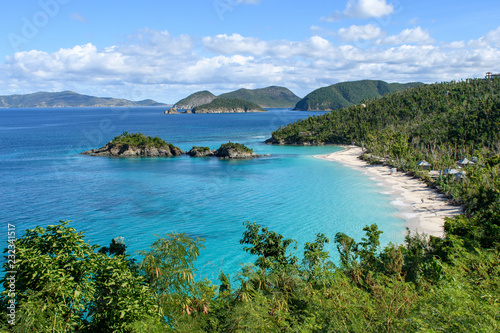 Blue lagoon with white sandy beach, green jungle and Islands on the horizon. Aerial view.