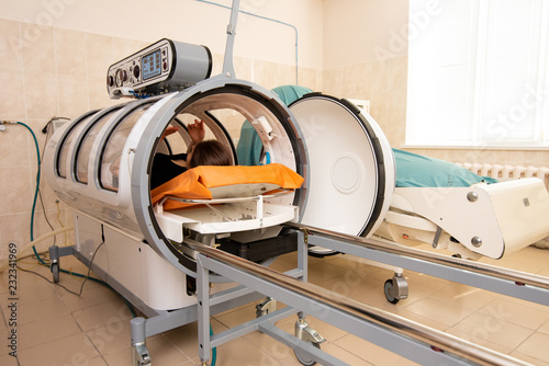 doctor in a white coat opens and pulls out a girl in a black T-shirt from the altitude chamber