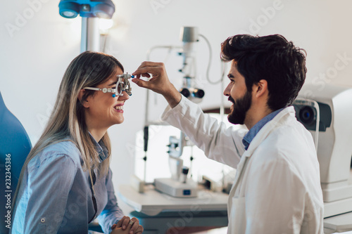 Optometrist checking patient eyesight and vision correction photo