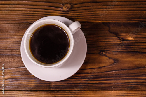 Cup of dark coffee on wooden table. Top view