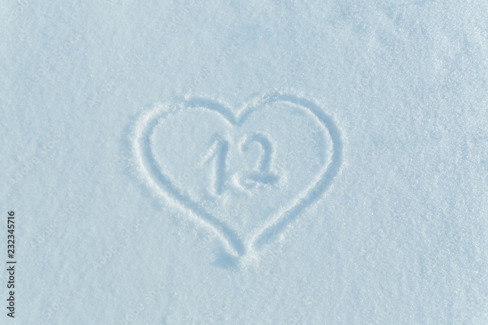 The number twelve drawn on the snow surrounded by a frame in the form of a heart. The number twelve drawn on the snow surrounded by a frame in the form of a heart.