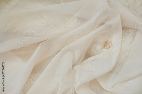 wedding rings lie on Pink fabric texture for abstract background, design and wallpaper, soft and blur style, smooth.