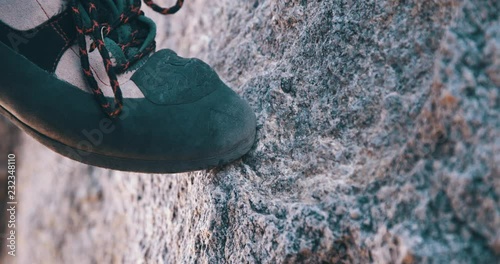 Close up of climbing shoe on tan granite rock