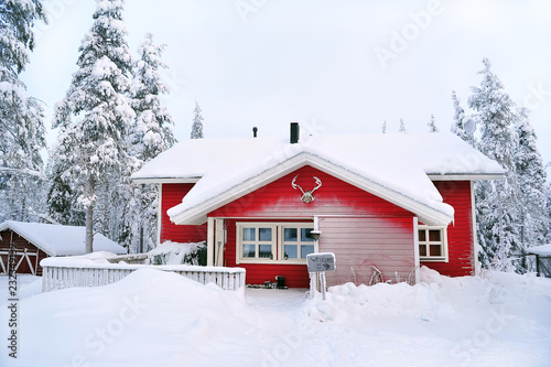 red wooden house in a snow covered landscape