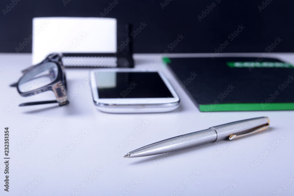 Business concept. Top view of kraft spiral notebook, glasses, smartphone and black pen isolated on background for mockup. Business concept. Top view of kraft spiral notebook, glasses, smartphone and black pen isolated on background for mockup.