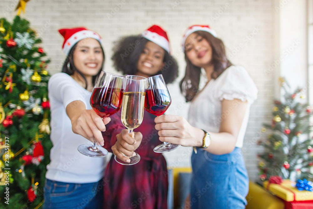 Obraz premium Happy girl friends having new year party toasting with red wine and champagne