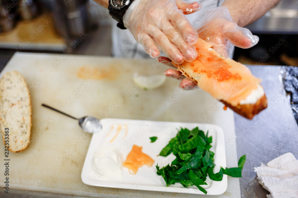 chef prepares a baguette with salmon