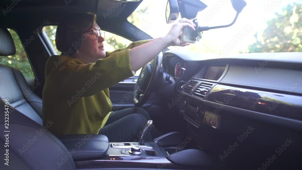 woman in the car sets the phone on the bracket woman in the car sets the phone on the bracket