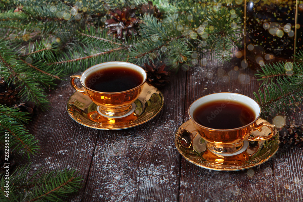 Two cups of coffee on wooden background with fir branches. New year and Valentine's day concept. Breakfast for two. Two cups of coffee on wooden background with fir branches. New year and Valentine's day concept. Breakfast for two.