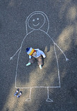 Missing: little child drawing with a piece of chalk on asphalt his mother tha