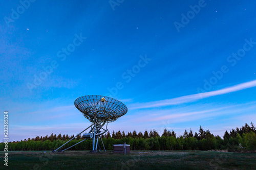 The Westerbork Synthesis Radio Telescope (WSRT) during dusk, with a light cloudy sky and stars a little visible photo