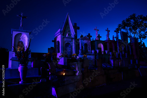 Dark blue lightened tombstones with buring candles during dawn in Cementerio General in Merida, Mexico photo