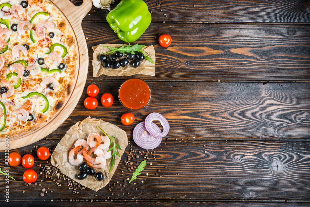Food background design. Seafood, shrimps and olives on a dark wood. Pizza ingredients. Food background design. Seafood, shrimps and olives on a dark wood. Pizza ingredients.