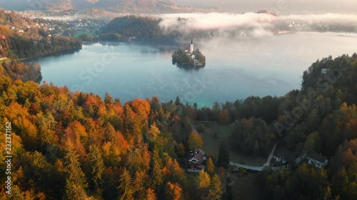 4K Flying around romantic Bled lake with chapel on the island at foggy sunrise