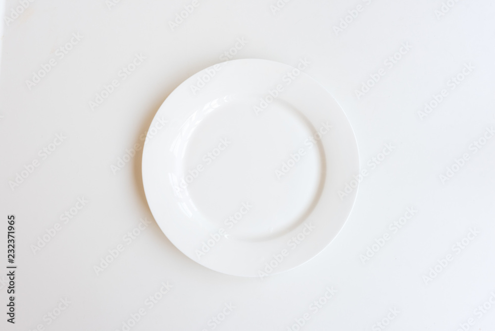 Ceramic plate on white background from above (selective focus) Ceramic plate on white background from above (selective focus)