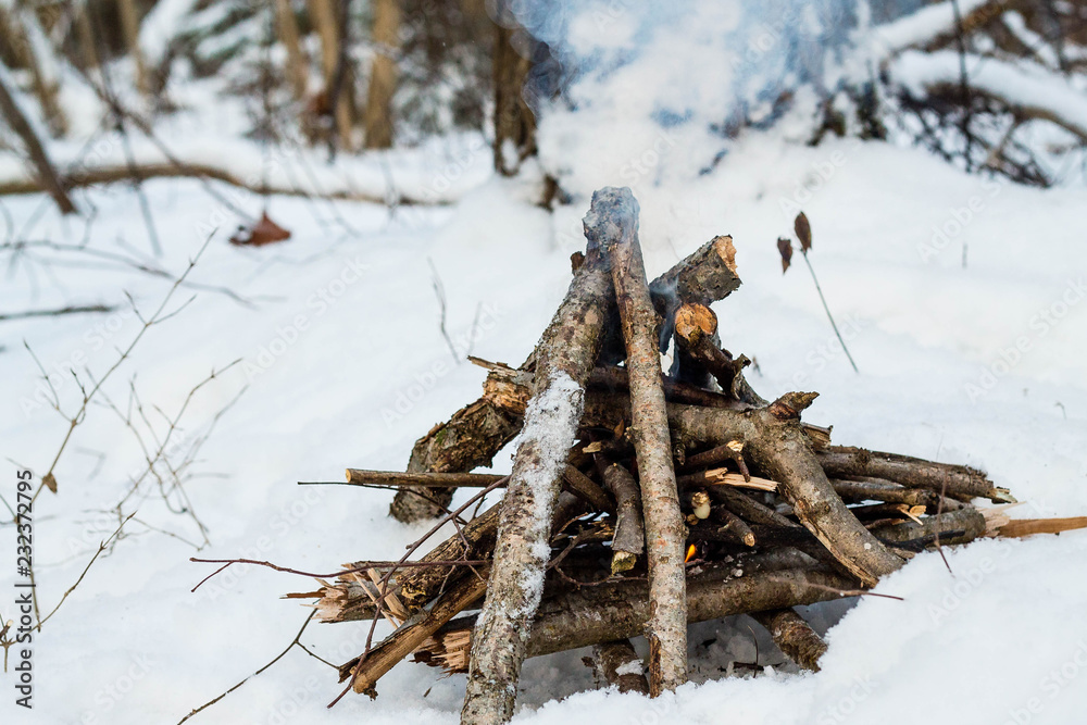 Kindle a fire in the woods in winter