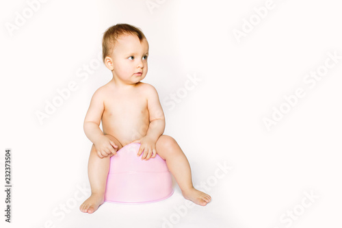 Infant child baby girl toddler sitting on potty toilet stool pot isolated on a white background