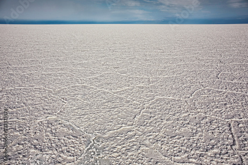 A low angle view of cracked salt flat in Salar de Uyuni  Potosi region  Bolivia. The weather is clear with blue sky.