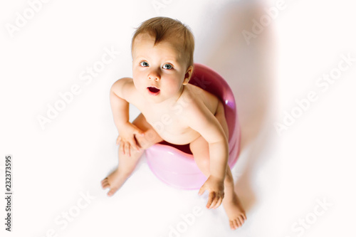 baby girl sits on a children's pot, toilet on a white background