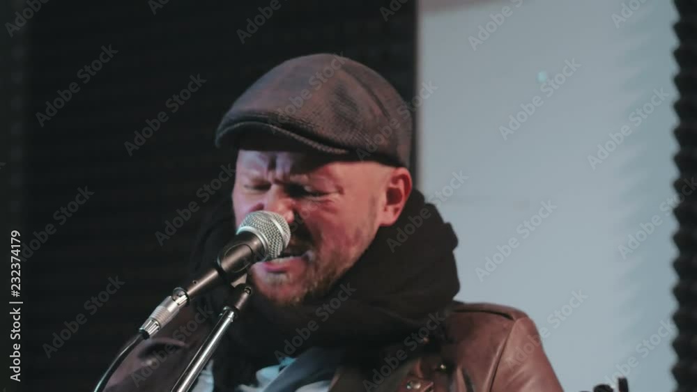 Portrait of middle-aged man singing song in microphone Portrait of middle-aged man singing song in microphone