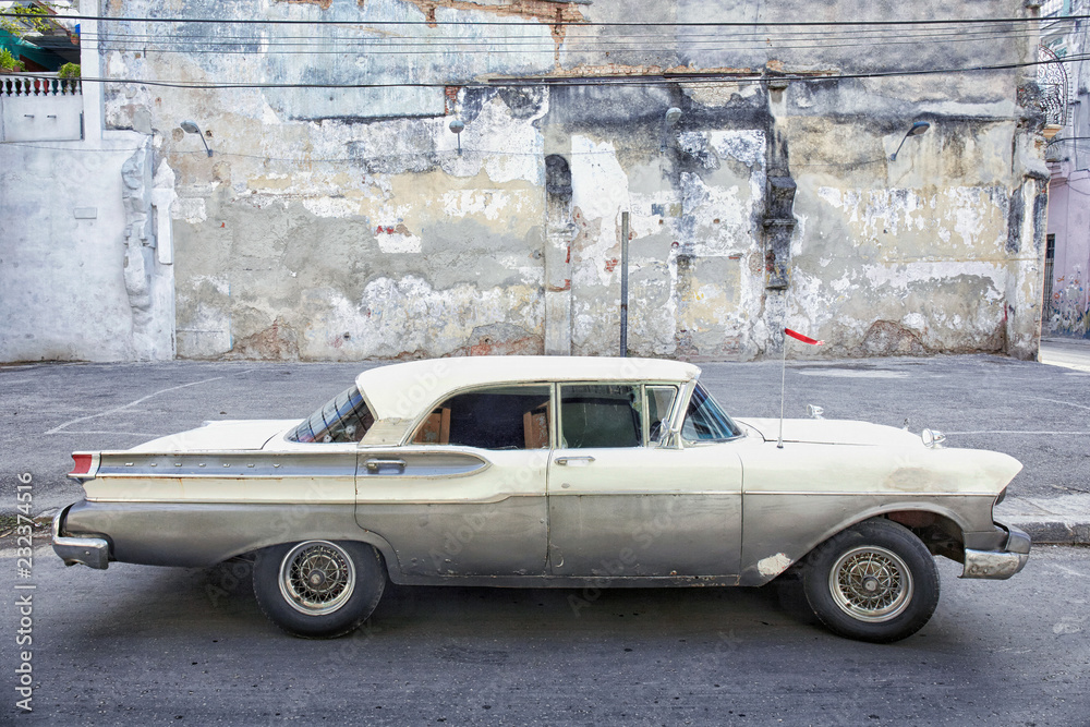 A grey and green American car still running on the streets of Cuba.