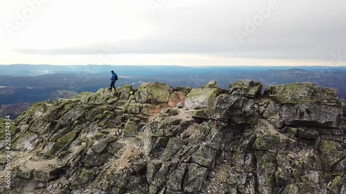 Aerial sideways shot of a man walking on a mountain ridge in Southern Norway