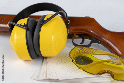 Shield and pneumatic weapon on a white table. Accessories for sport shooting at the shooting range. photo