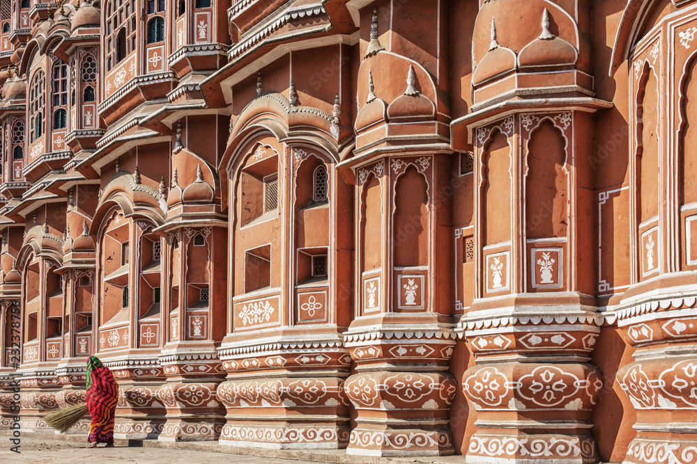 Woman in front of Hawa Mahal palace or Palace of the Winds in Jaipur city, India