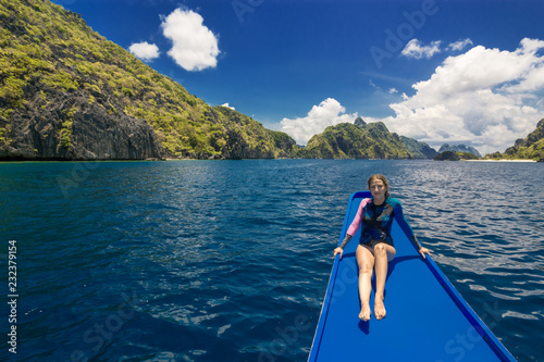 Young woman on the boat and looking forward into lagoon. Travelling tour in Asia: El Nido, Palawan, Philippines.
