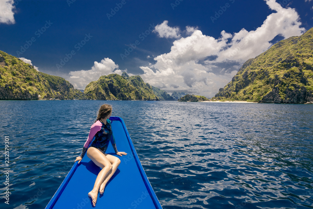 Young woman on the boat and looking forward into lagoon. Travelling tour in Asia: El Nido, Palawan, Philippines. Young woman on the boat and looking forward into lagoon. Travelling tour in Asia: El Nido, Palawan, Philippines.
