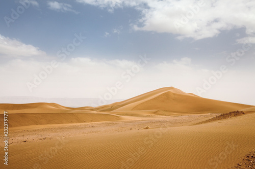 Desert Landscape of zagora in Marocco  with a blue sky  stones  bushes and clouds