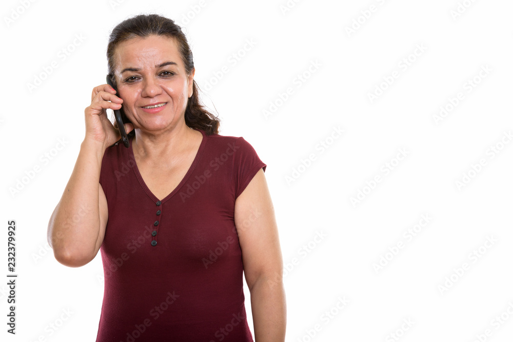 Studio shot of happy mature Persian woman smiling while talking Studio shot of happy mature Persian woman smiling while talking