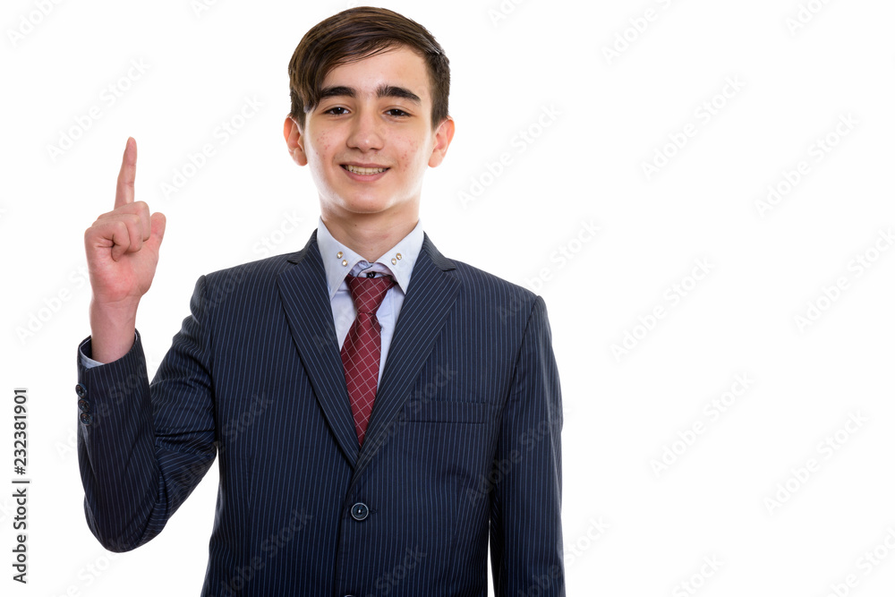 Studio shot of young happy Persian teenage businessman smiling w Studio shot of young happy Persian teenage businessman smiling w