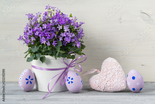 Beautiful Easter concept with easter eggs and a pot of flowers and textile heart