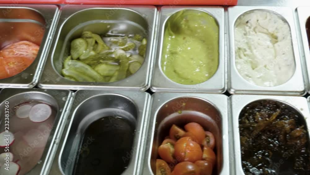 Cooking hamburger. Panorama of cheese, green chilli, pickled cucumber, onion, sauce, cherry tomatoes, radish. 4K