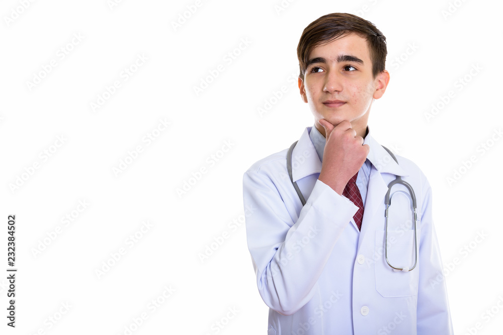 Studio shot of young handsome Persian teenage doctor thinking wh Studio shot of young handsome Persian teenage doctor thinking wh