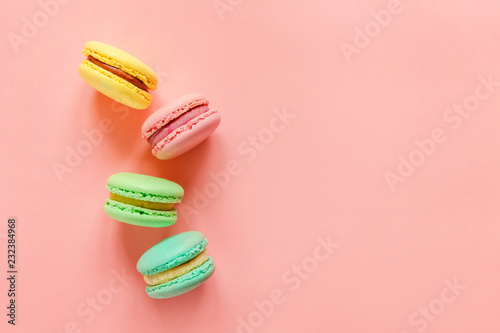 Sweet almond colorful pink biue yellow green macaron or macaroon dessert cake isolated on trendy pink pastel background. French sweet cookie. Minimal food bakery concept. Flat lay top view copy space